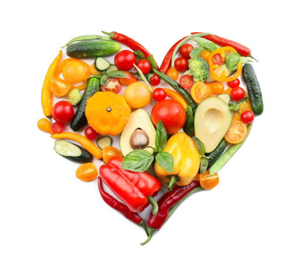 Heart made of various fresh vegetables on white background stock photo