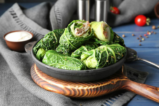 Pan with stuffed cabbage leaves on wooden board stock photo