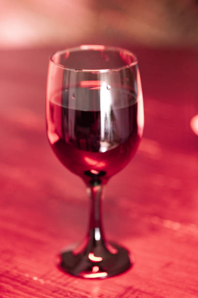istock Wine Glass on Table With Red Lights 1350767778
