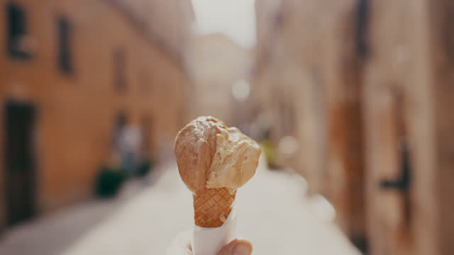 View of a person walking with ice cream, Tuscany, Italy.