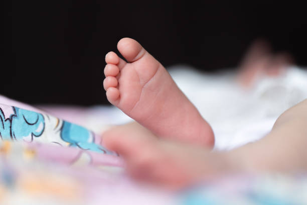One leg of a baby on a diaper with a picture