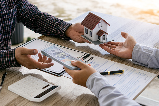 Dealers are recommending homes to new owners after agreeing to a home sales contract. Renting and Buying a House Idea Image of a real estate agent explaining to clients about an ownership agreement.