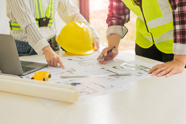 istock Two male and female engineers working on blueprints for the project worked with partners to create models and engineering tools in the house building concepts office. 1350771345