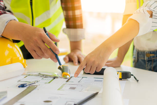 istock Two male and female engineers working on blueprints for the project worked with partners to create models and engineering tools in the house building concepts office. 1350771357