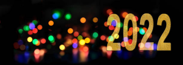 istock golden number 2022 new year  on blur multicolored lights  background 1350771445