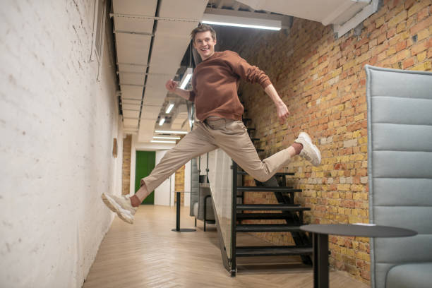 istock A young man looking happy and enjoyed in the office corridor 1350772156