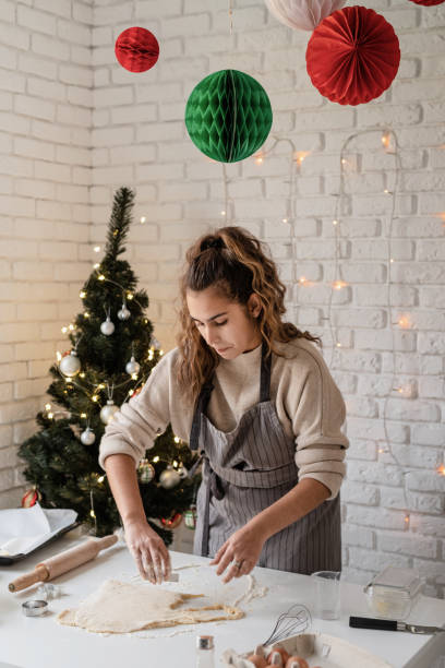 istock Smiling woman in the kitchen baking christmas cookies 1350772464
