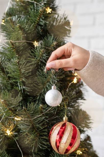 istock woman hand decorating the Christmas tree 1350774332
