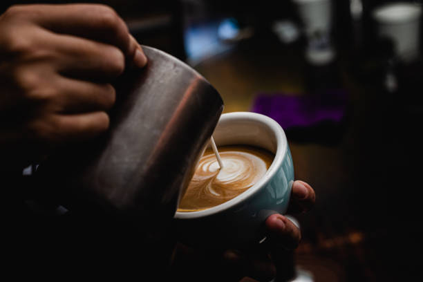 Barista making coffee latte art in coffee shop with coffee machine stock photo