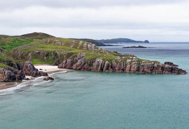 Beautiful sandy beaches in Achmelvich Bay surrounded by rugged countryside in the Scottish Highlands.