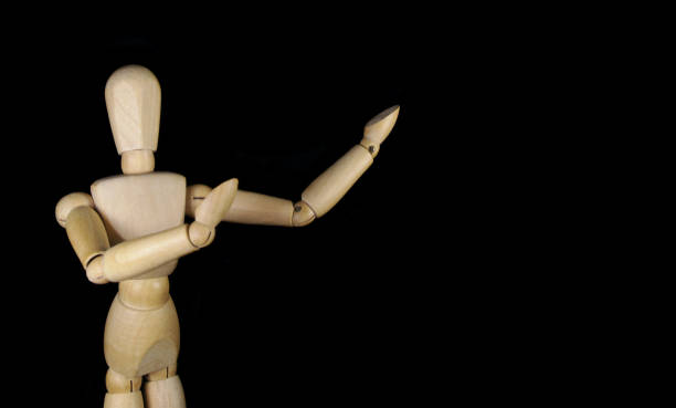 istock Wooden mannequin isolated on black background with room for text 1350780511
