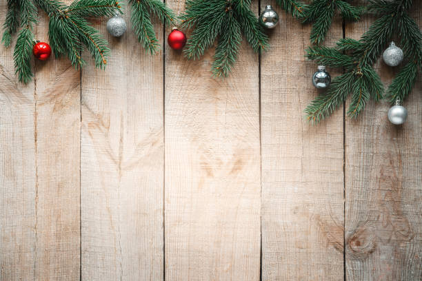 istock Christmas tree branches with red and silvier baubles on wooden background 1350781923
