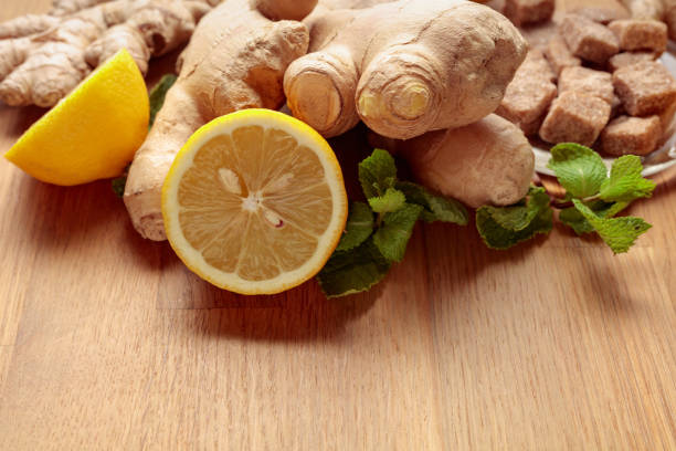 Ingredients for ginger tea. Ginger, lemon, mint and brown sugar on a old wooden table.