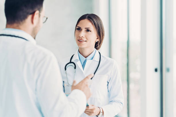 istock Female doctor talking with a colleague 1350785604