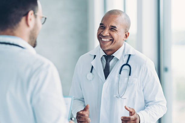istock Smiling middle aged doctor talking with a colleague 1350785606