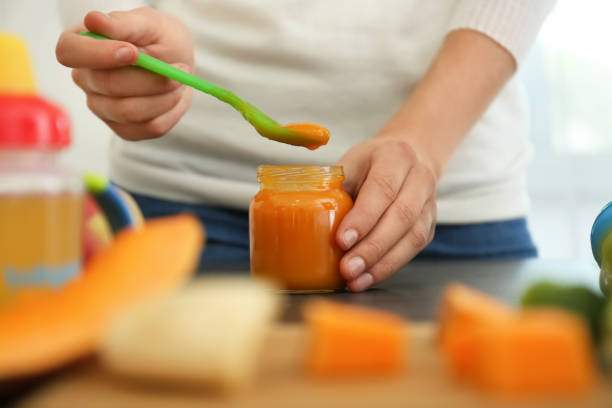 Woman preparing healthy baby food in kitchen, closeup Woman preparing healthy baby food in kitchen, closeup baby food stock pictures, royalty-free photos & images