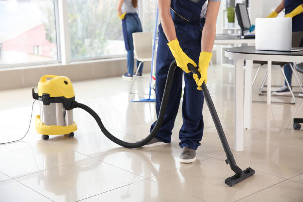 Janitor hoovering floor in office stock photo