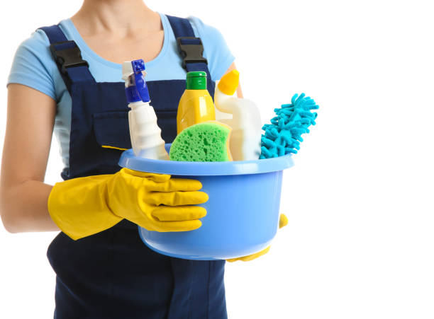 Woman with cleaning supplies on white background stock photo