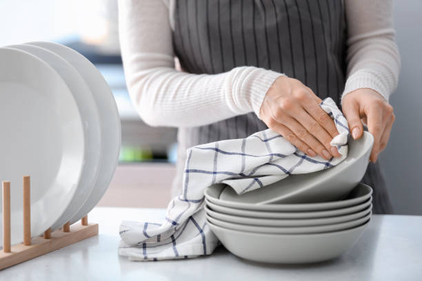 istock Woman wiping plate with towel in kitchen 1350787002