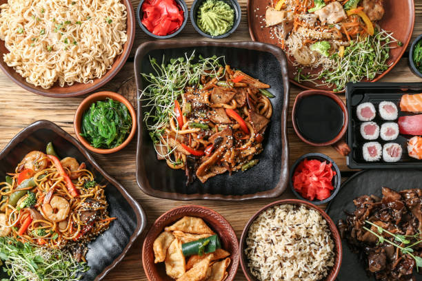 Assortment of Chinese food on wooden table stock photo