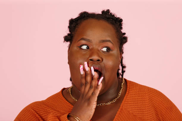 istock Shocked black woman covers face with hands on pink background 1350788066