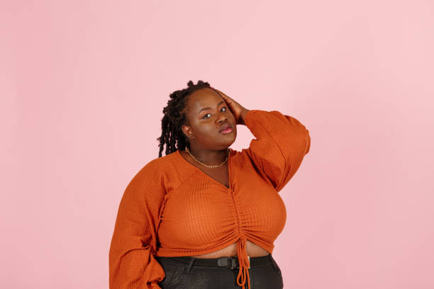 istock Attractive young black woman poses for camera on pink background 1350788205