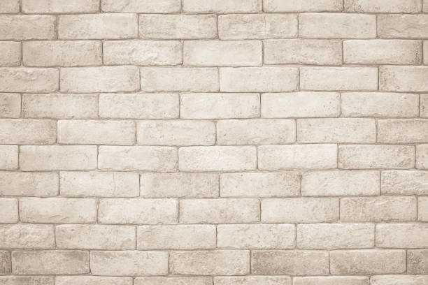 istock Cream and white brick wall texture background. Brickwork and stonework flooring interior rock old pattern clean concrete grid uneven bricks design stack. Background of old vintage brick wall 1350788501