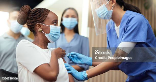 Cropped Shot Of An Attractive Young Businesswoman Getting Her Covid Vaccination From A Female Nurse In The Office Stock Photo - Download Image Now