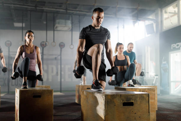 istock Athletic people having cross training with dumbbells in a gym. 1350789638