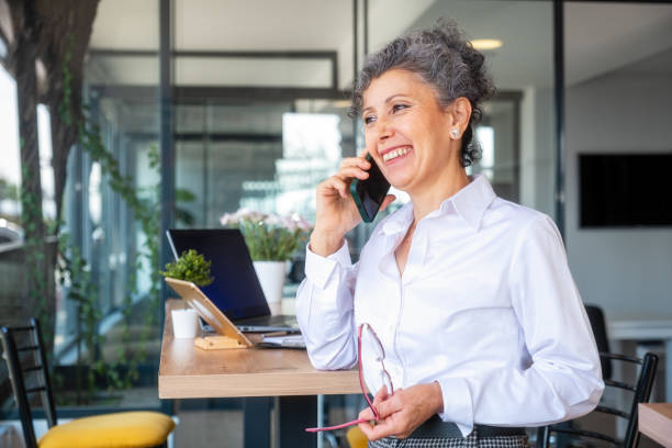 femmes âgées parlant au téléphone - senior adult retirement financial advisor finance photos et images de collection