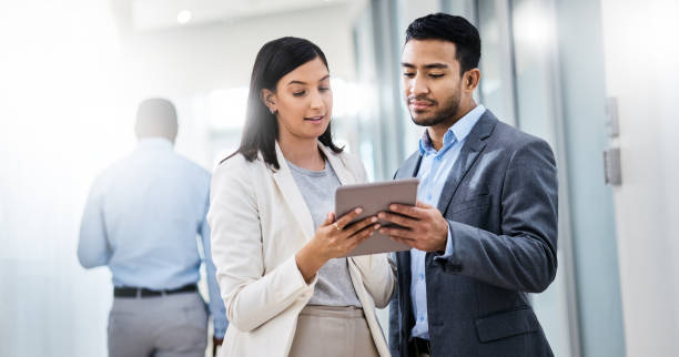 istock Shot of two businesspeople discussing something on a digital tablet 1350790874