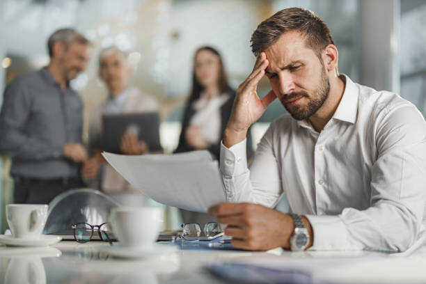 istock Worried businessman going through paperwork in the office. 1350791929