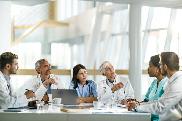 istock Team of general practitioners talking on a meeting at doctor's office. 1350793602