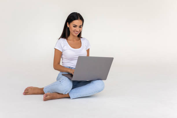 istock Young woman working on a laptop isolated over a white backgorund 1350793945