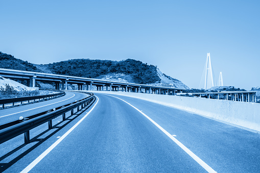 ramp road leads to the bridge, highway background with blue tone