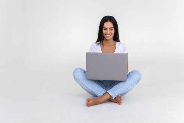 istock Young woman working on a laptop isolated over a white backgorund 1350794933