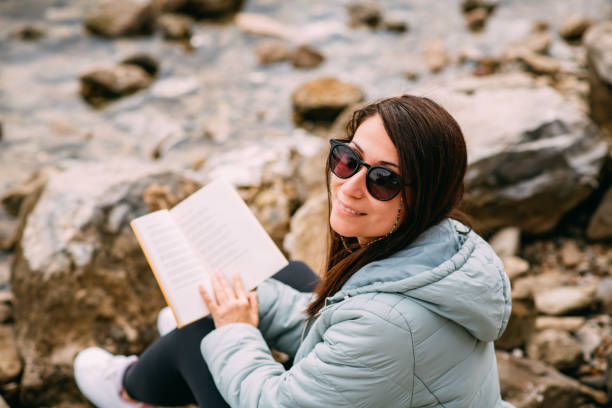 Young Woman Reading a Book on the Beach