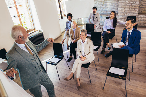 Business people attending seminar in modern office