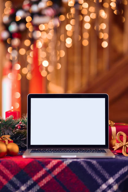istock Laptop computer mockup white blank screen on Christmas table background. 1350795157