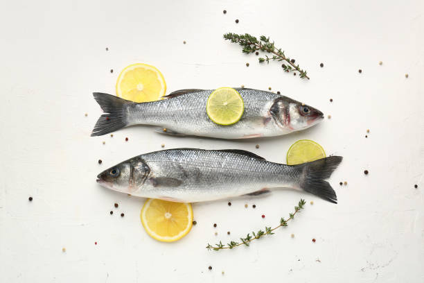 istock Tasty fresh seabass fish with spices on white background 1350798635