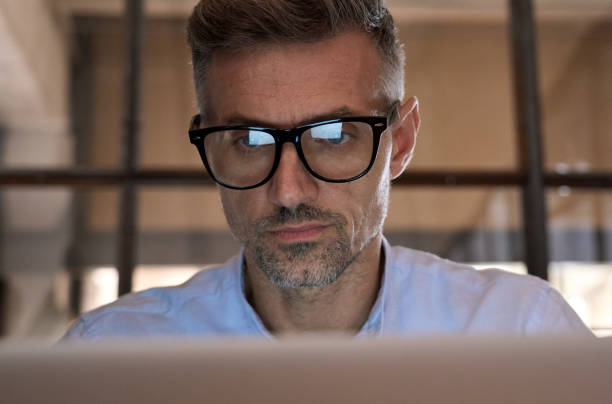 istock Concentrated business man looking at computer screen reflecting in glasses. 1350800568