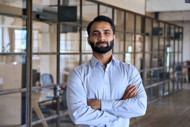 istock Confident successful indian businessman looking at camera standing in office. 1350800616