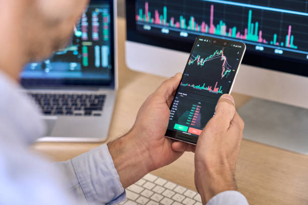 istock Crypto trader broker using phone app analyzing stock market on cell phone. 1350800664