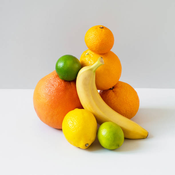 istock Grapefruit, orange, banana, lime, tangerine and lemon balanced on grey background. Yellow, orange and green color fruits with vitamin C and antioxidants. Healthy vegetarian diet 1350804100