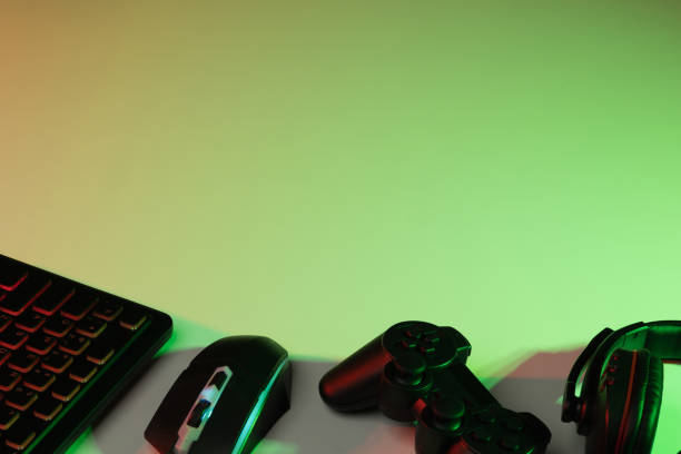 istock Accessory gaming keyboard joystick mouse headphone with blank space. Gadget for gamer playing video game online in the neon light darkroom. 1350804389
