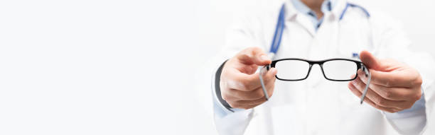 istock Optometrist holds glasses to try on 1350804425