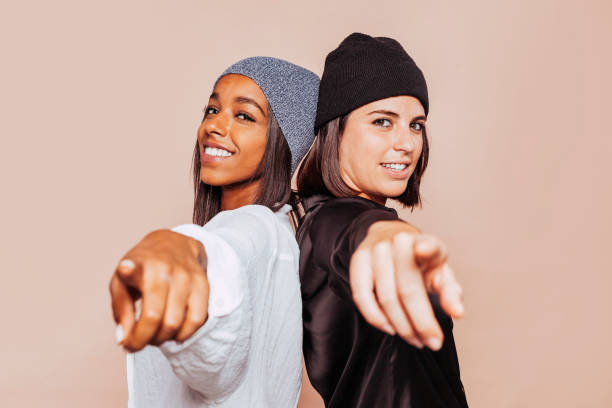 istock Two stylish smiling woman point finger at you at studio 1350805389