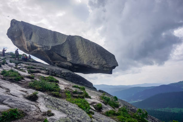Tourists near the Hanging Stone Natural Park Ergaki, Russia - July 17, 2019: Tourists near the Hanging Stone hanging stone stock pictures, royalty-free photos & images