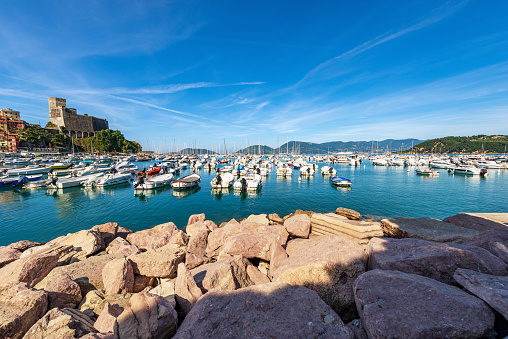 Lerici, Italy - June 12th, 2021: The ancient Castle of Lerici town (1152-1555) view from the port with many boats moored. Tourist resort on the coast of the Mediterranean sea (Ligurian Sea), Gulf of La Spezia, Italy, Europe. It is a polygonal fortification that stands in a dominant position on the rocky promontory of Lerici inlet.