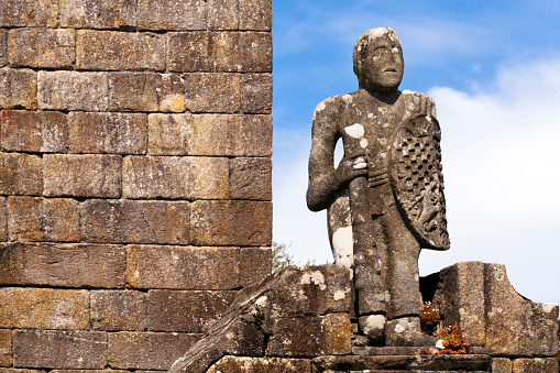 Medieval Balboa sculpture protecting San Benito church, clear sky and stone wall background, Fefiñanes public townsquare,  Cambados winemaking village, Pontevedra province, Rias Baixas, Galicia, Spain.